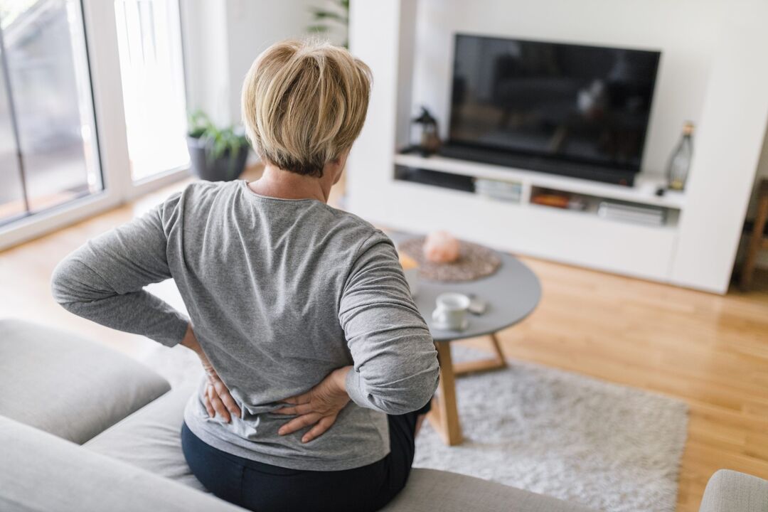 Uma mulher está preocupada com dores nas costas na região lombar